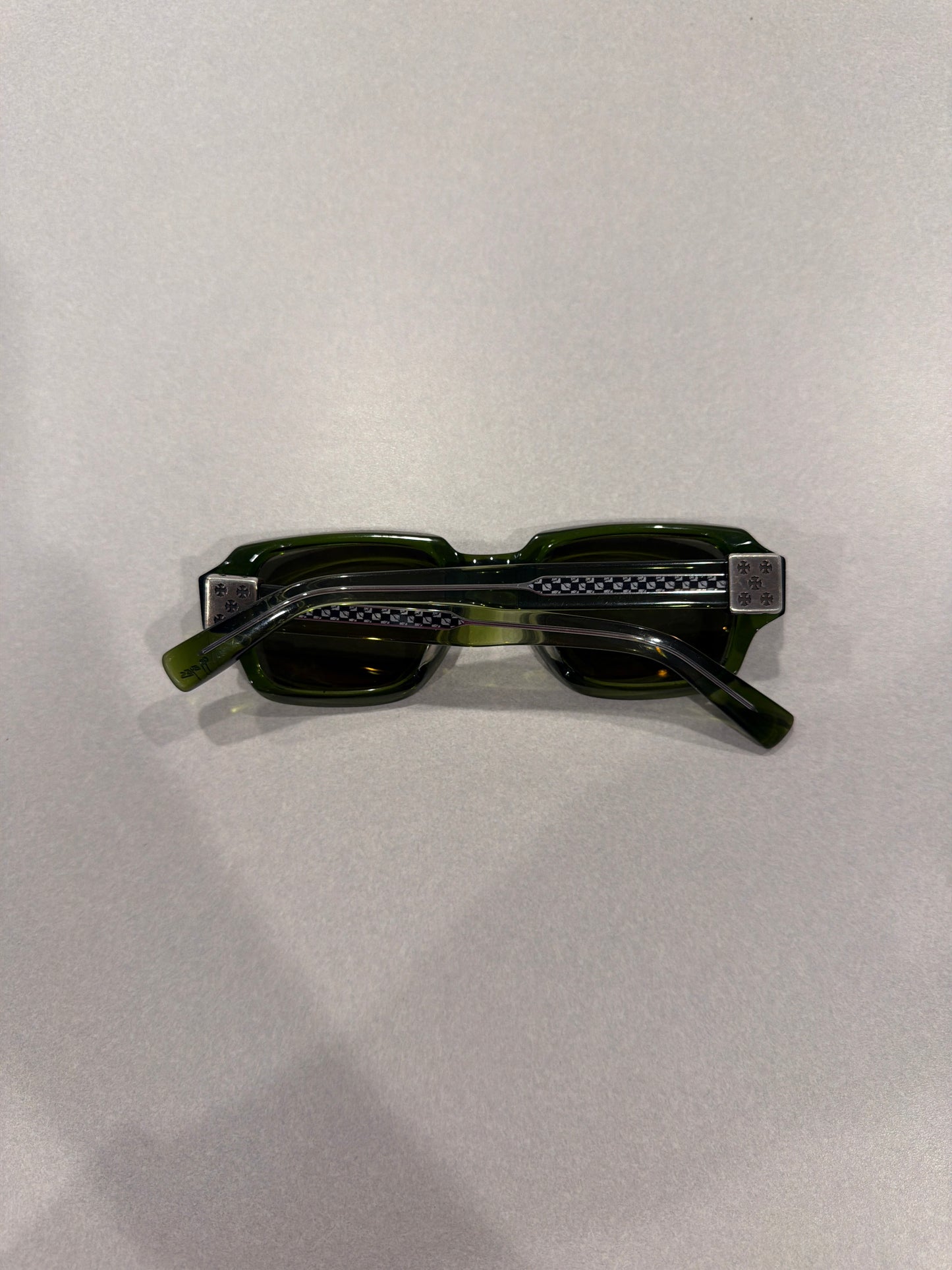 Chrome Hearts Matty Boy green sunglasses folded top-down view showing silver cross-engraved temple plates