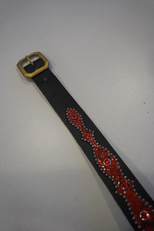 Vintage studded snakeskin belt flat view with black red scale texture, metal buckle and dense stud rows