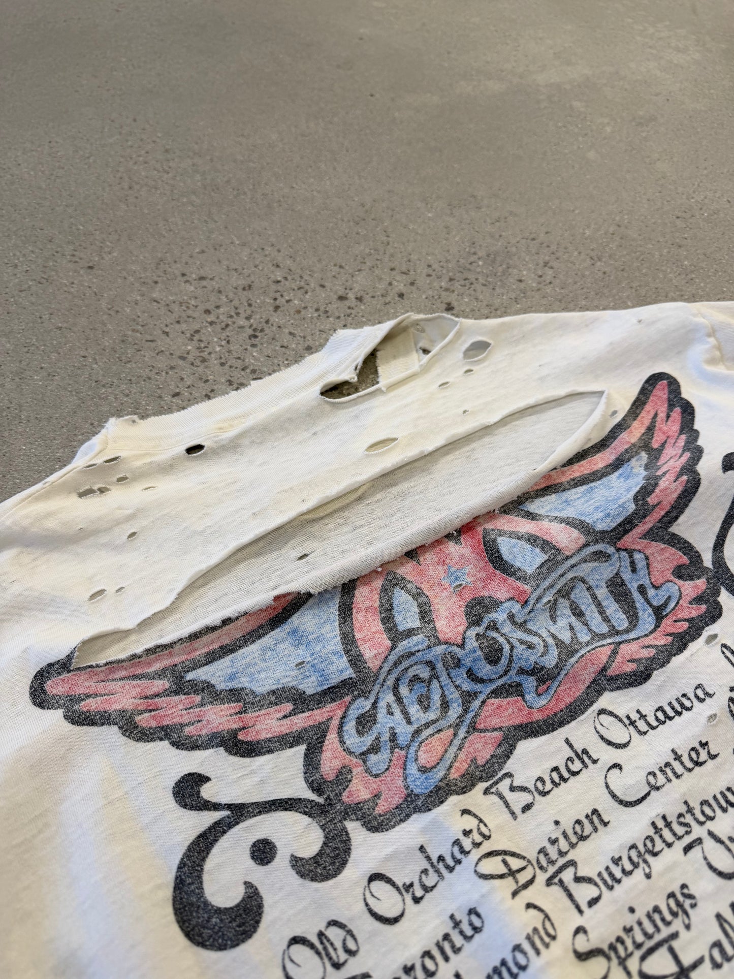 Aerosmith Nine Lives vintage tour tee detail showing faded graphic print and worn black cotton fabric.