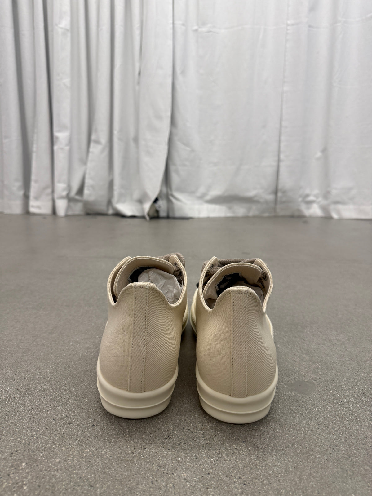 Heel view of Rick Owens DRKSHDW milk low-top sneakers showing smooth leather backs and chunky white sole
