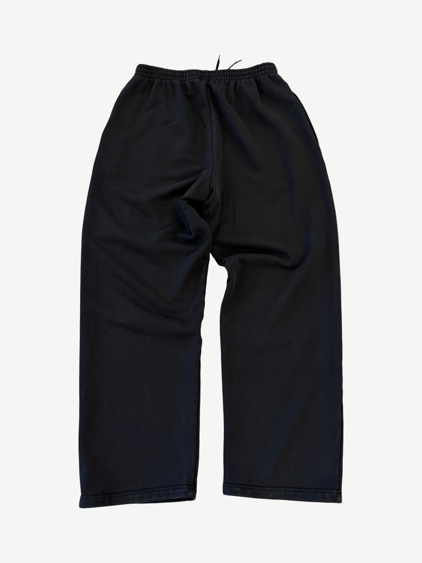 Back of Balenciaga 3M black sweatpants with elastic cuffs, side pockets and tapered relaxed silhouette.