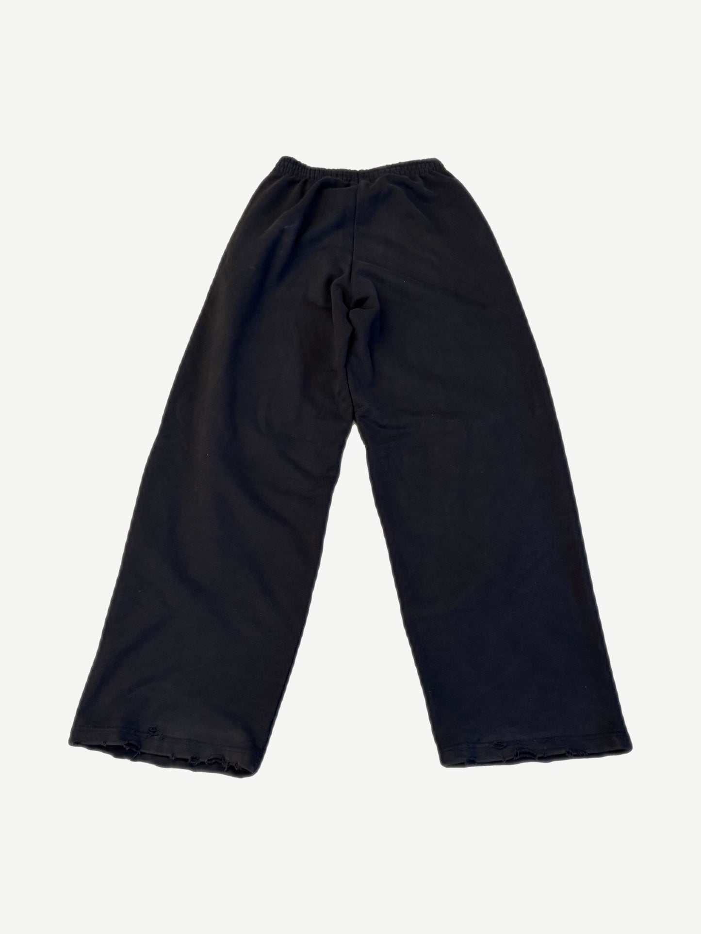 Balenciaga black baggy sweatpants back plain view with distressed raw hem detail