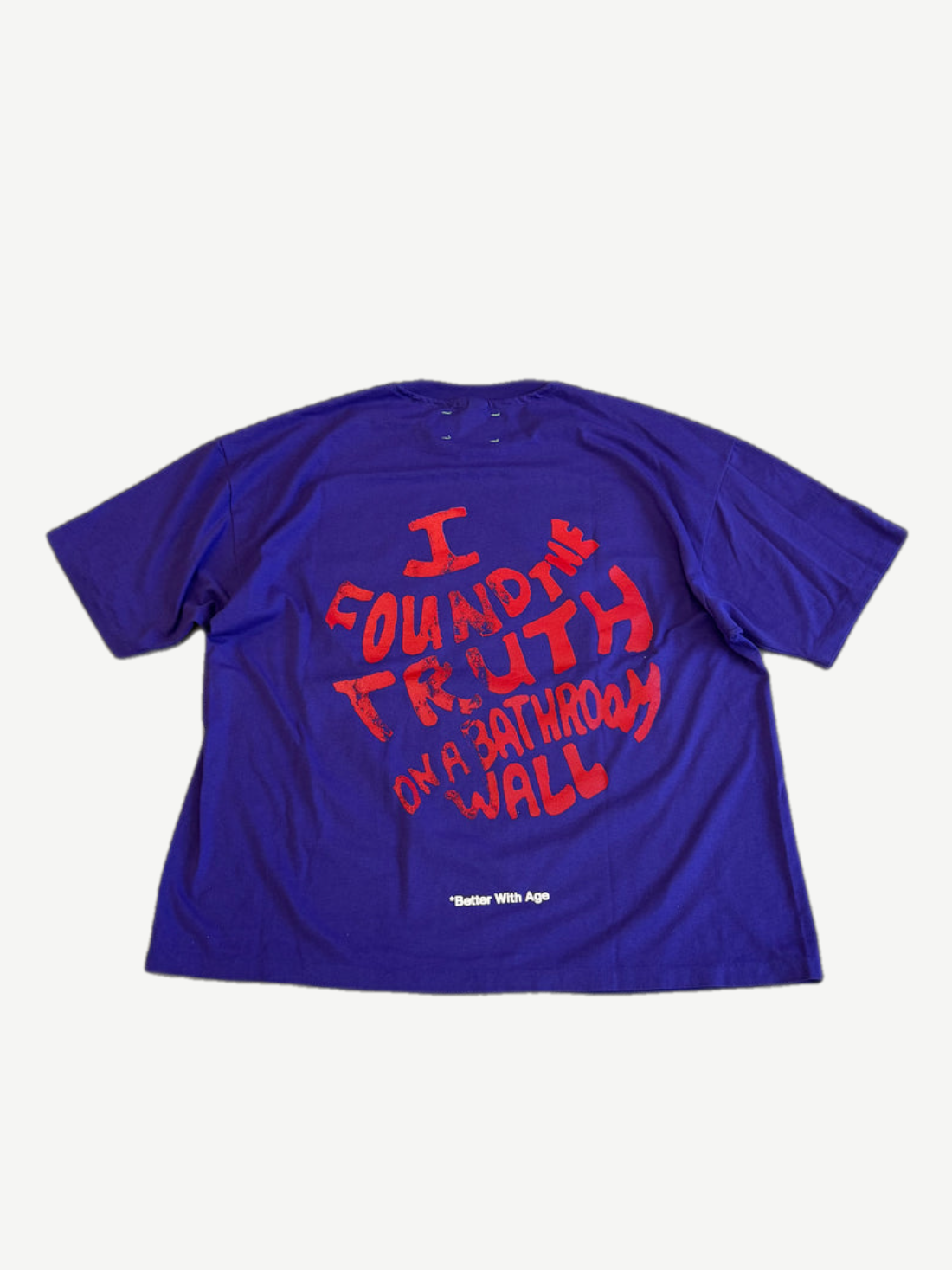 Back of Better With Age purple tee with red I Found the Truth on a Bathroom Wall handwritten print.