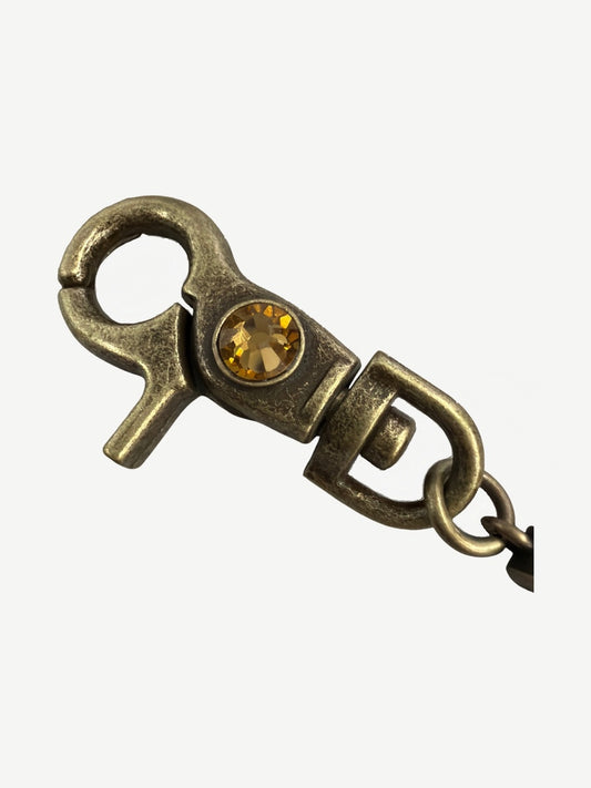 Bottega Desires brass wallet chain close-up of swivel lobster clasp set with a faceted amber crystal