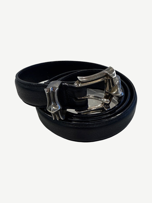Chrome Hearts three piece black leather belt coiled showing silver dagger buckle and matching tip hardware.