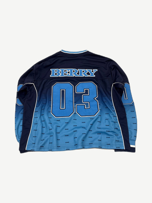 Raspberry Hills blue Legend hockey jersey back with Berry name plate, 03 number and tonal allover monogram.