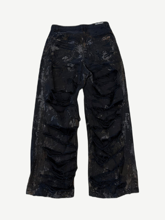 Back of Balenciaga mud wash destroyed jeans showing ripped pocket detailing and oversized straight leg silhouette.