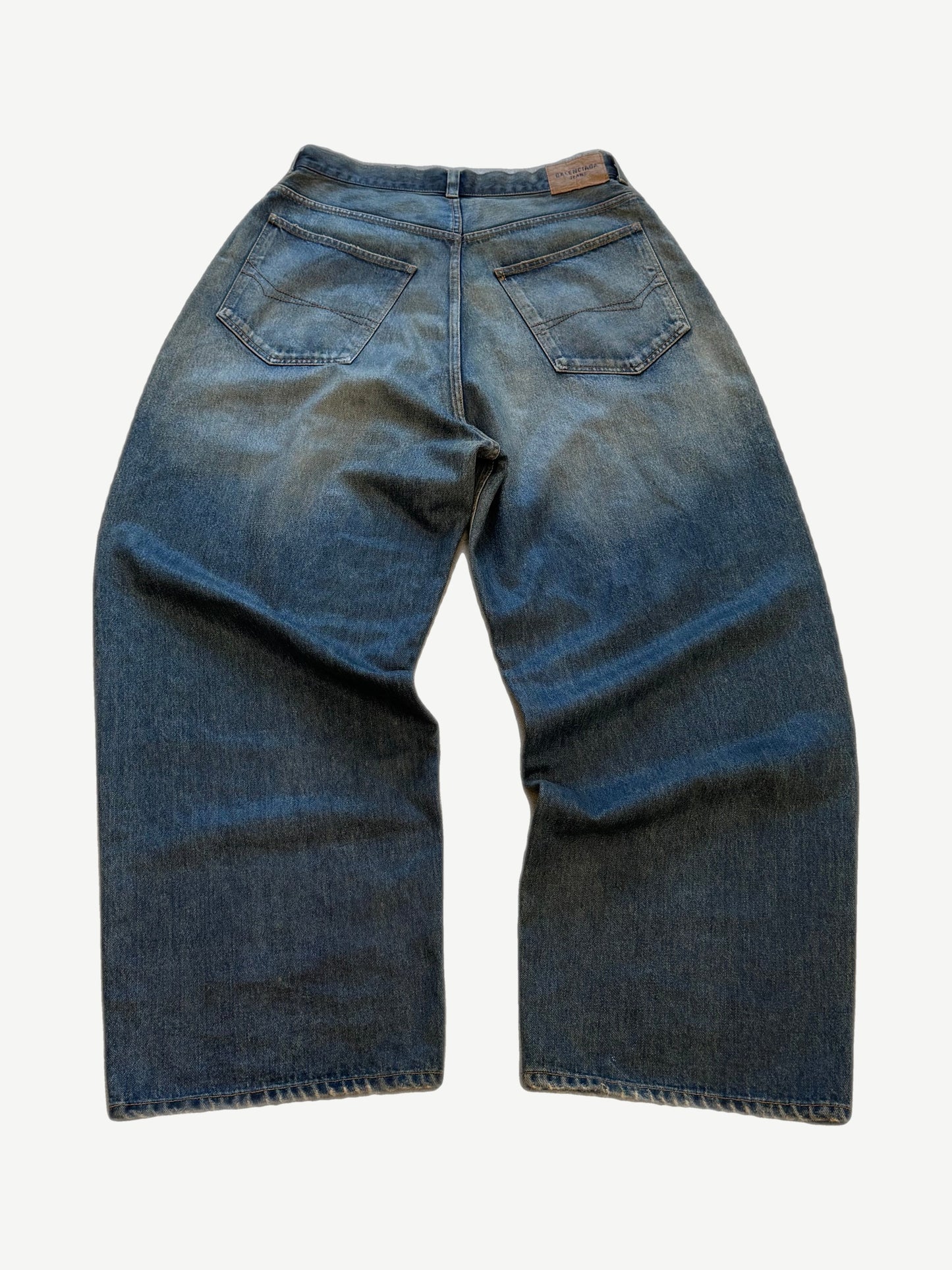 Balenciaga waxed blue baggy jeans alternate view showing slick wax-coated denim and oversized fit.