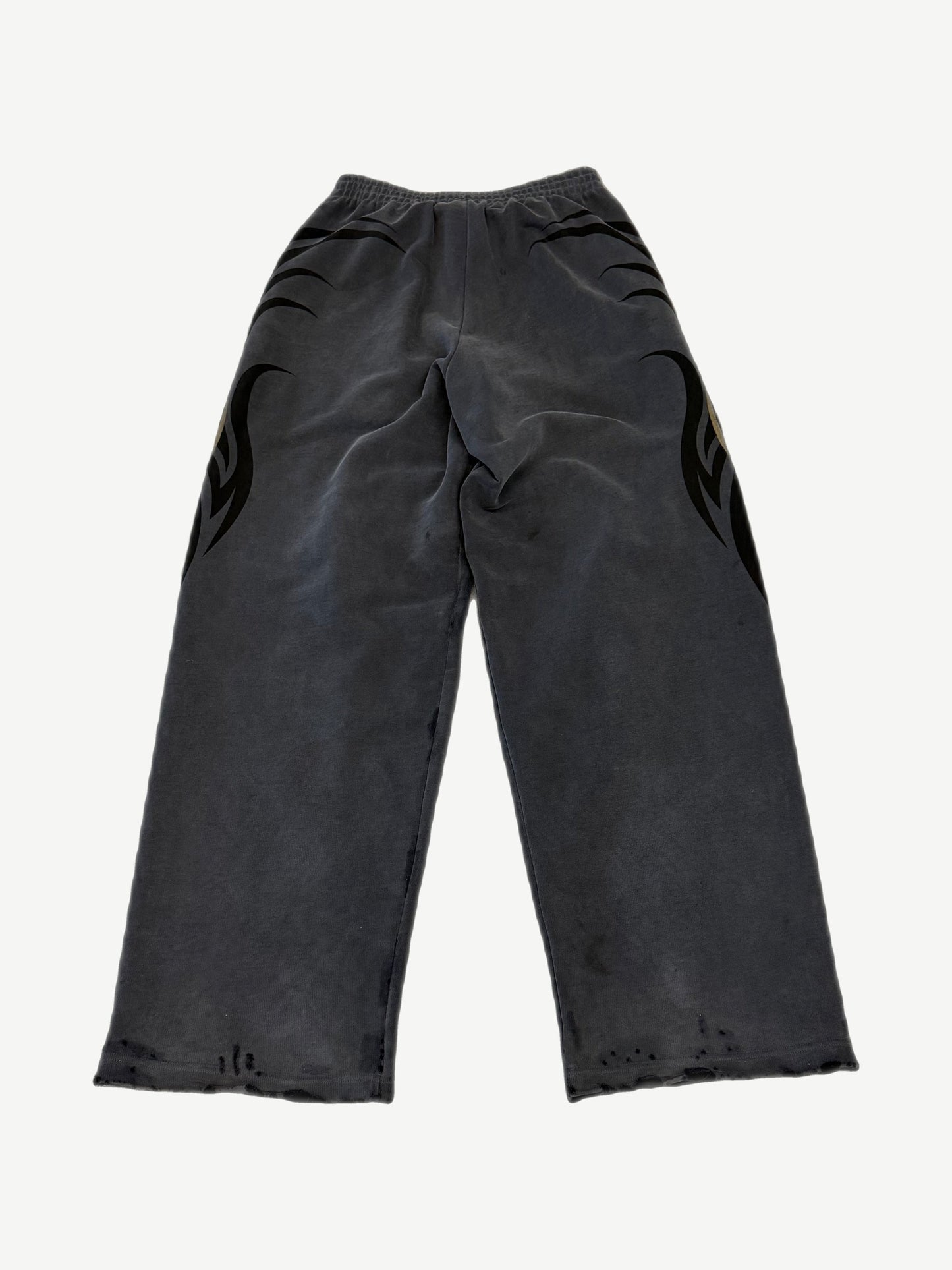 Balenciaga washed gray sweatpants with tacky gold tribal flame print across hips and distressed raw hems
