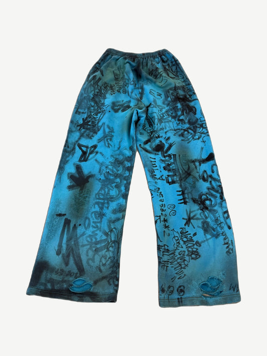 Balenciaga blue graffiti skater sweatpants back view showing wide loose fit and tagged jersey fabric.