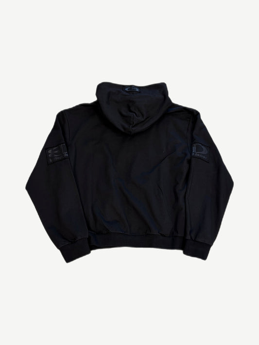 Back view of Bottega Desires black tech zip-up showing clean back panel and tonal sleeve logo patches