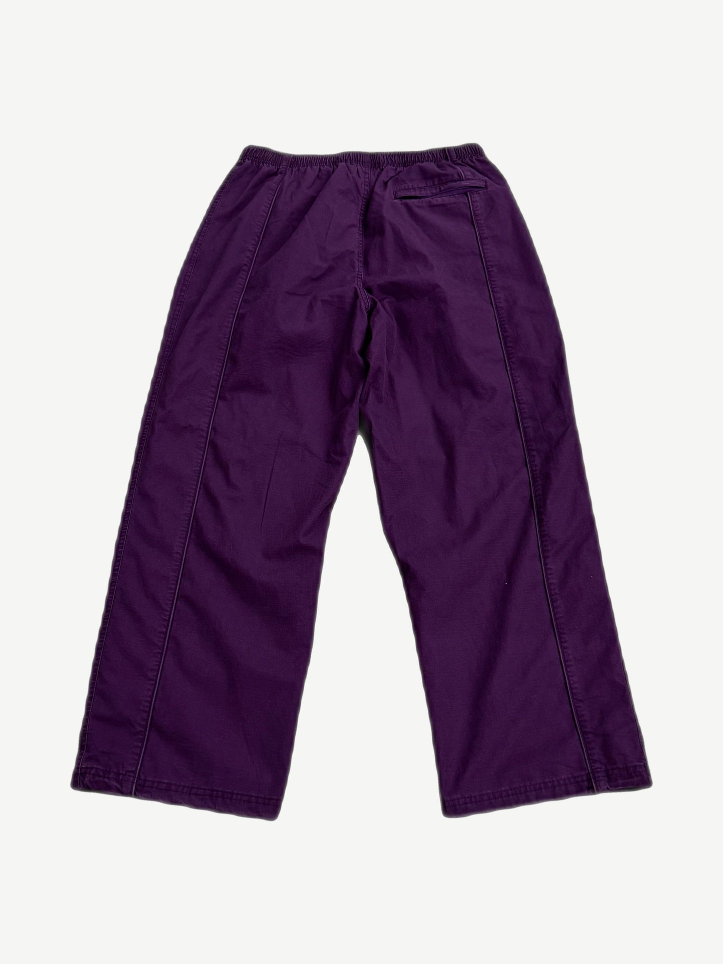 Supreme Umbro plum ripstop track pants back view with elastic waist, back pocket and tonal side seam piping.