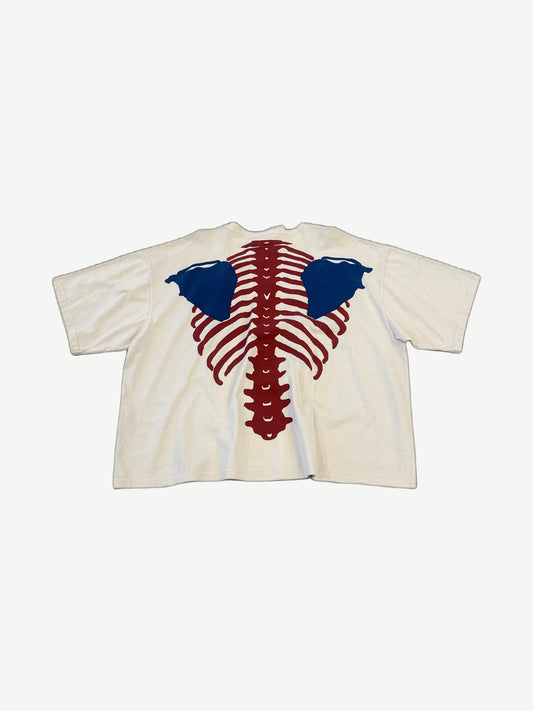 Kapital cream Bone 2 Tone tee back with red ribcage spine and blue scapula bone print graphic.
