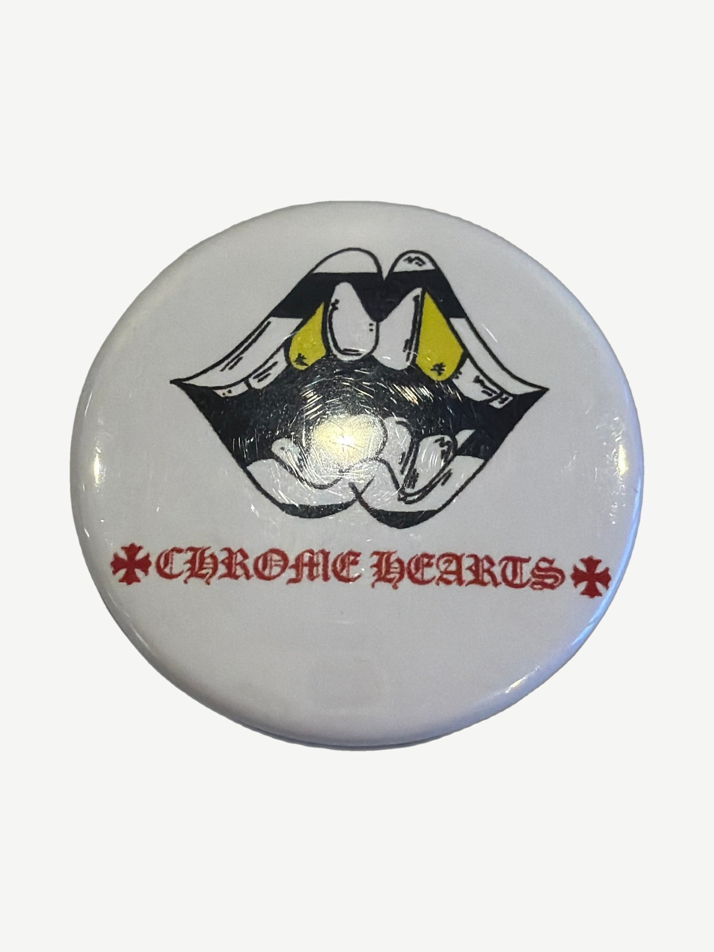 Chrome Hearts Matty Boy enamel pin in yellow and red with Matty Boy character figure and crisp outlines.