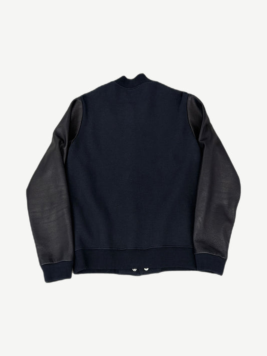 Back view of Chrome Hearts varsity jacket in navy wool with black leather raglan sleeves and ribbed cuffs
