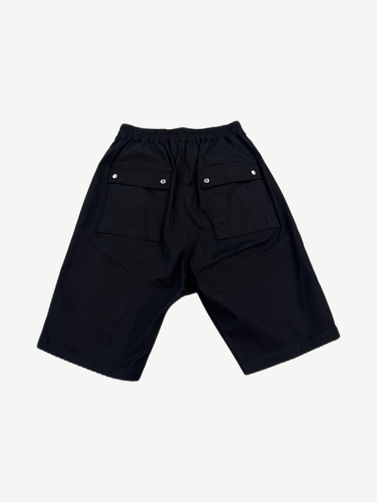 Rick Owens black Bela cargo shorts back view showing dropped seat, snap closures and tapered hem.