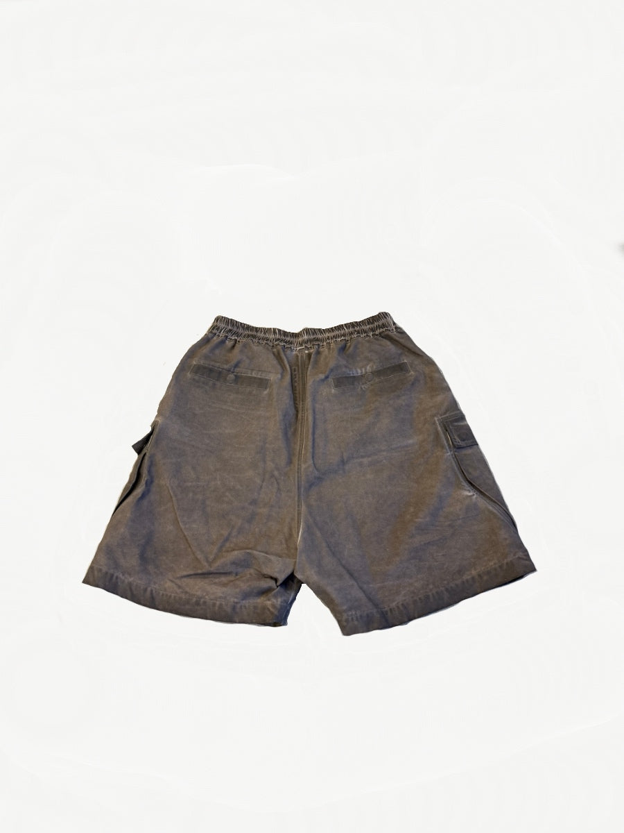 Rick Owens DRKSHDW Dust Bela shorts, back view showing elastic waist and welt pockets on faded fabric