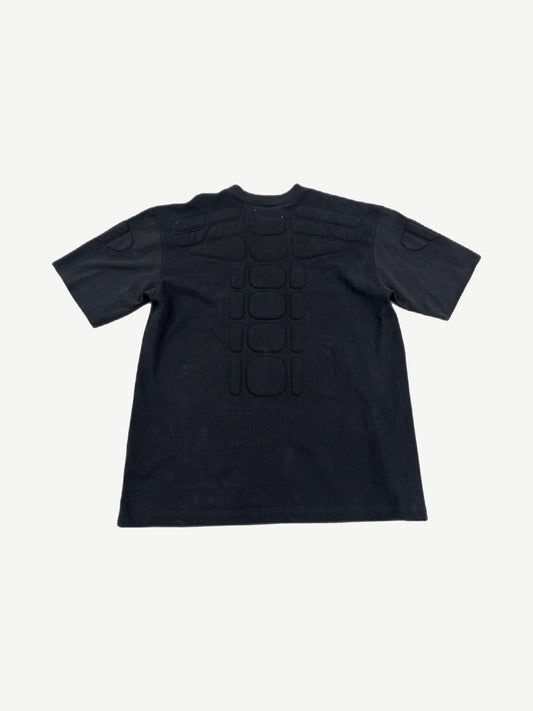 Satoshi Nakamoto black moto tee back with padded spine ribs and shoulder armor panels.