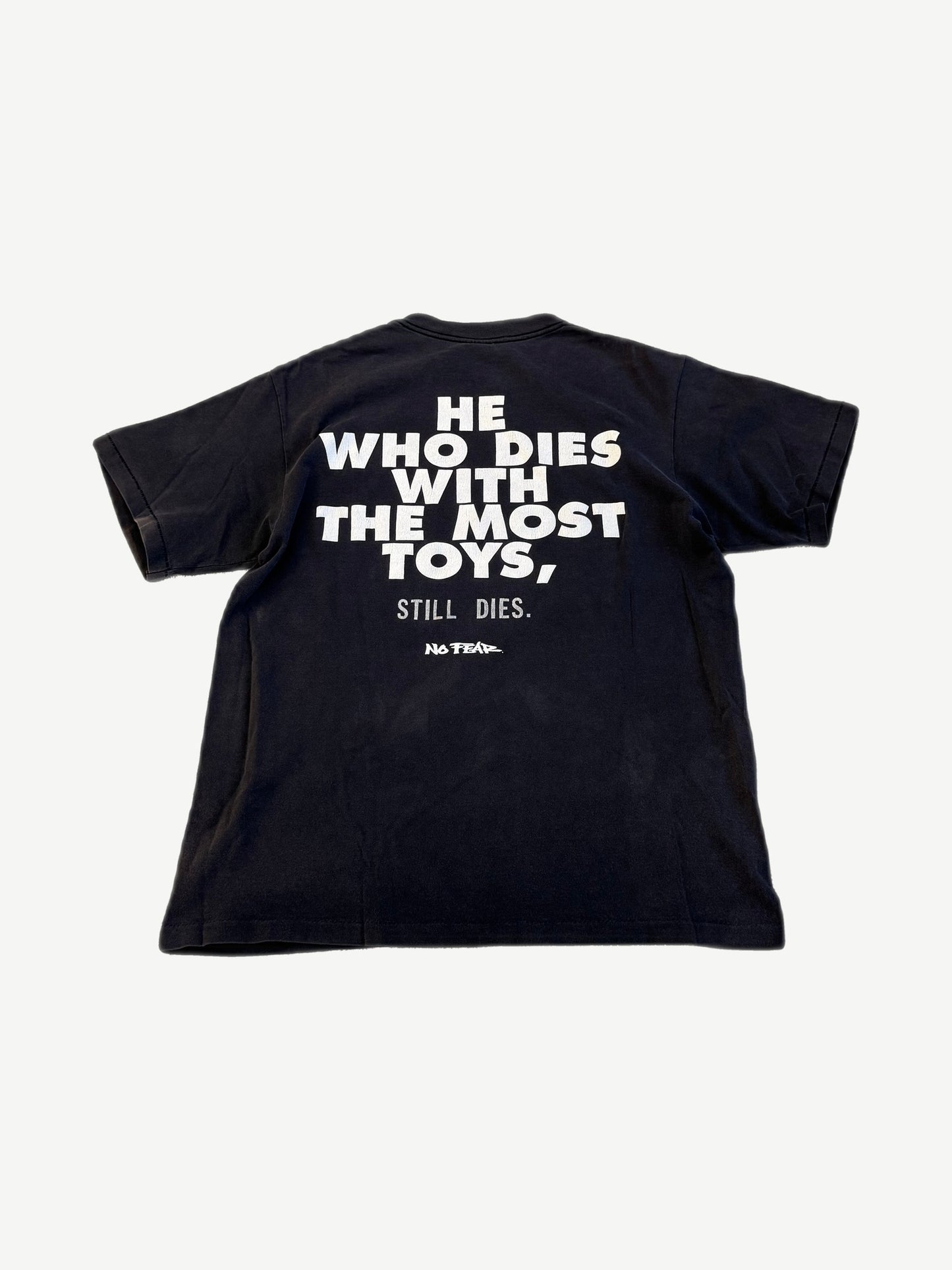 Vintage No Fear black tee back with bold He Who Dies With The Most Toys Still Dies slogan print