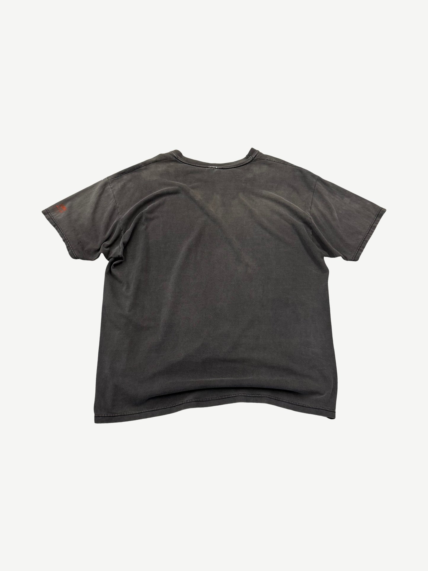 Back view of vintage washed black Punisher t-shirt with sun-faded gray tones and small orange sleeve graphic