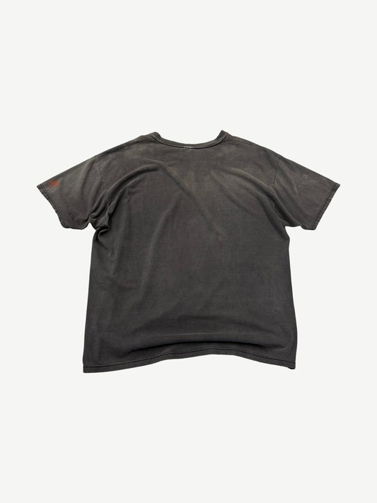 Back view of vintage washed black Punisher t-shirt with sun-faded gray tones and small orange sleeve graphic