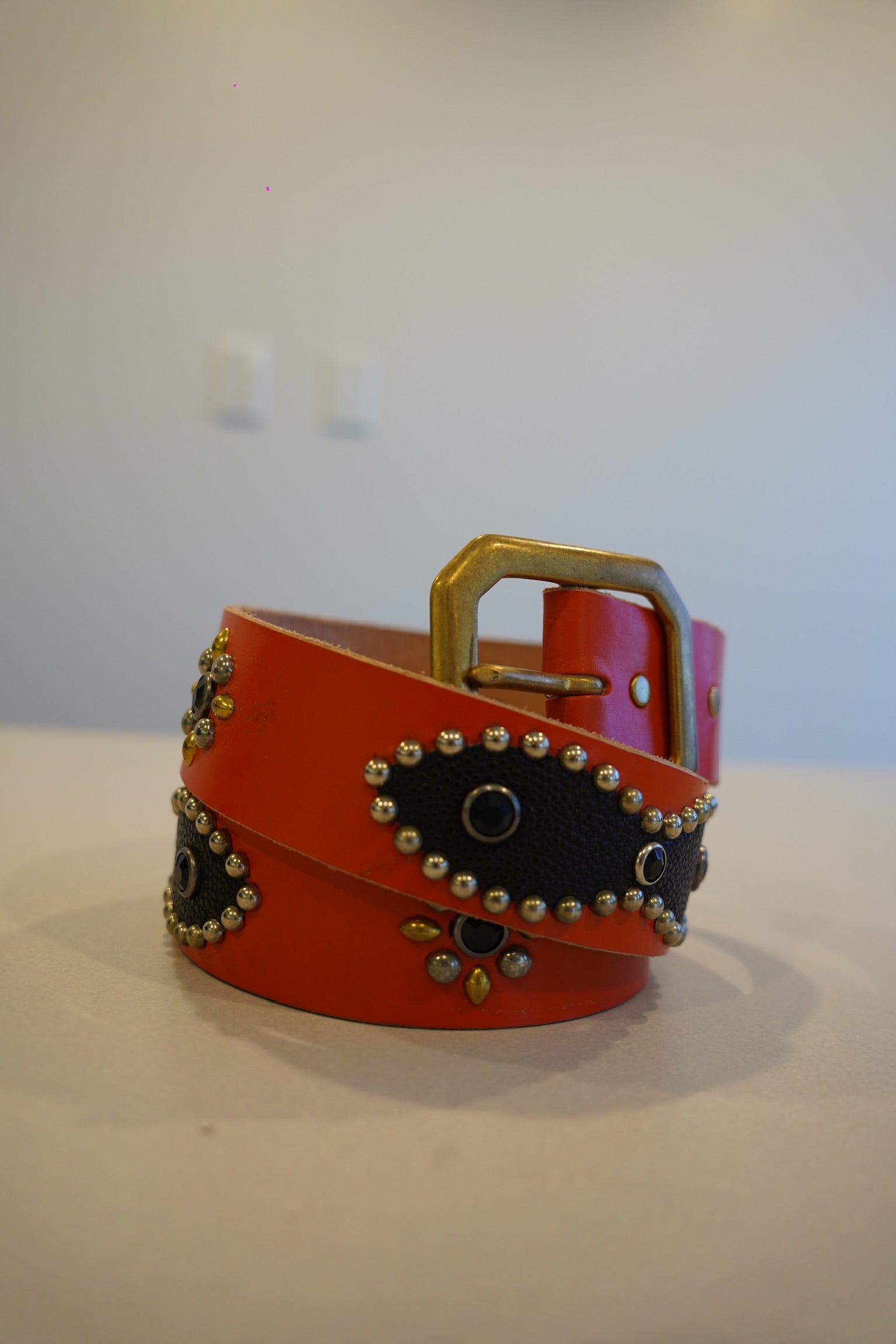 Vintage orange and black leather studded belt with silver pyramid studs and dual-grommet buckle, full length