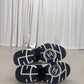 Chanel low top trainer outsole pair showing navy rubber tread with white CC circle logo on each sole