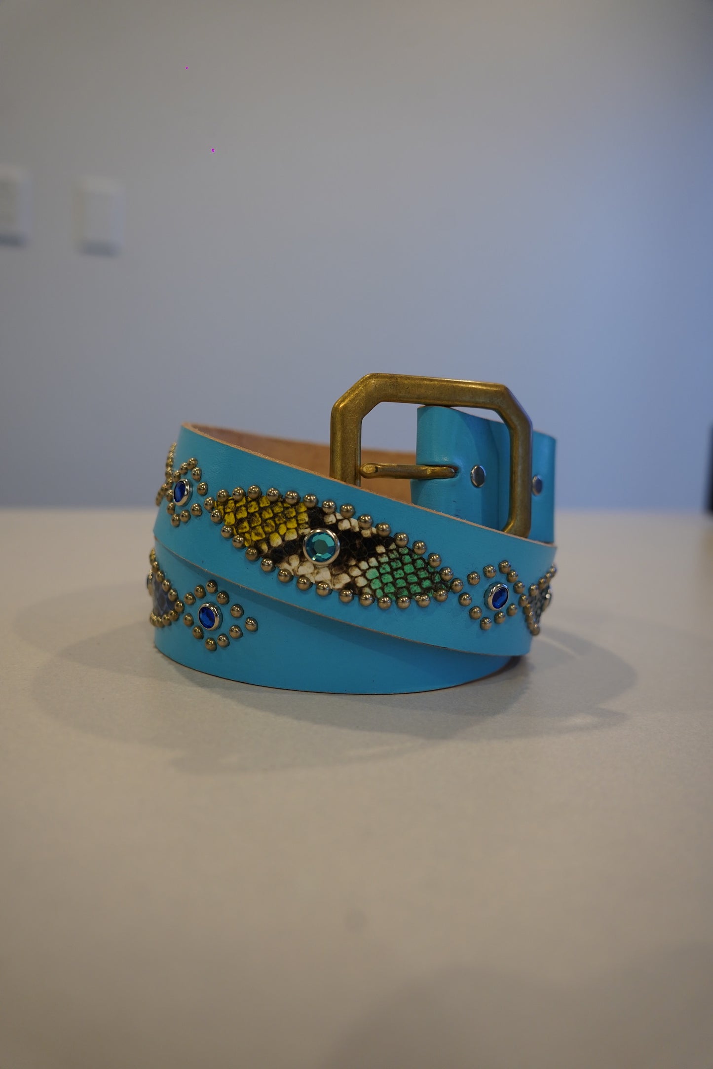Vintage light blue leather belt with brass buckle, snakeskin inlay panels and silver studs around blue gem