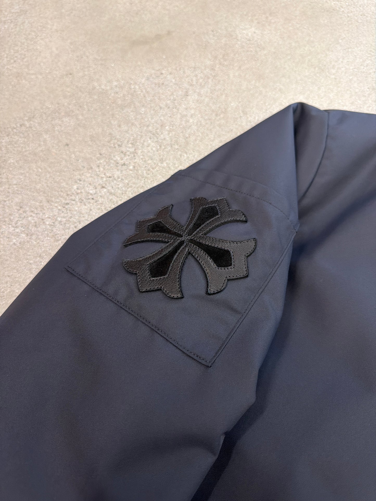 Chrome Hearts black Cobra racing jacket sleeve detail showing black leather Maltese cross patch