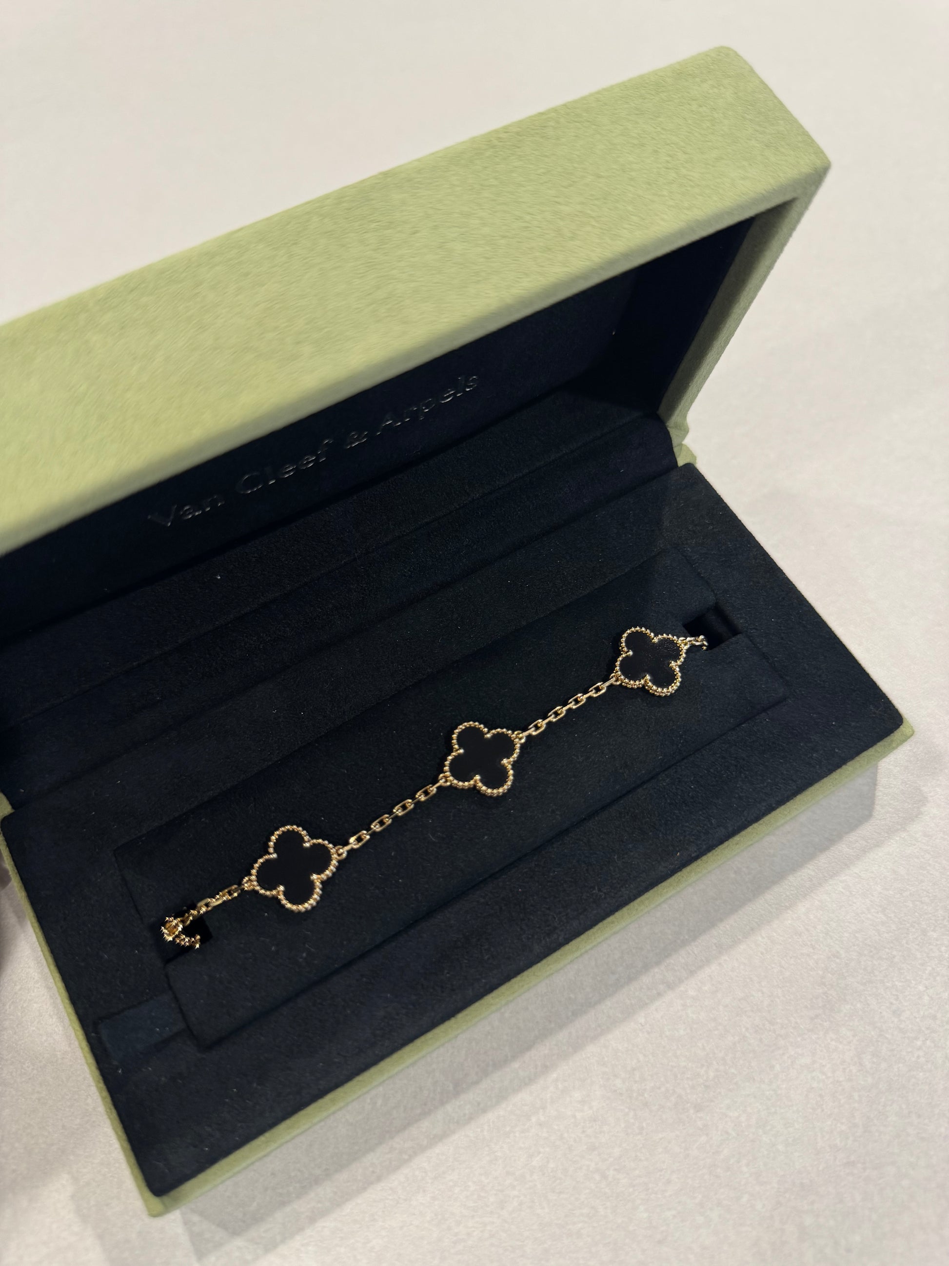 Van Cleef & Arpels Alhambra bracelet detail view showing onyx clover motif and 18k gold bead setting