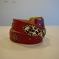 Vintage red cowhide leather belt with allover silver pyramid stud detailing and silver-tone roller buckle.