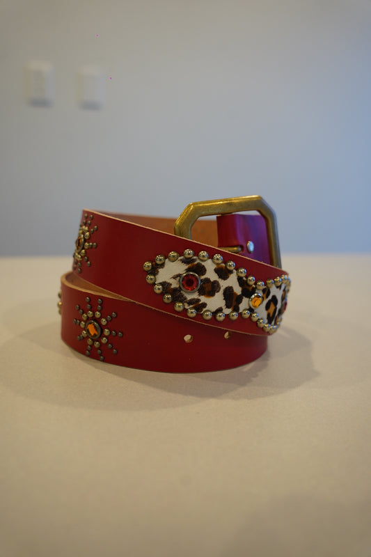 Vintage red cowhide leather belt with allover silver pyramid stud detailing and silver-tone roller buckle.