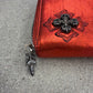 Chrome Hearts red wallet close-up of dagger zipper pull and black plus cross patch on red metallic leather