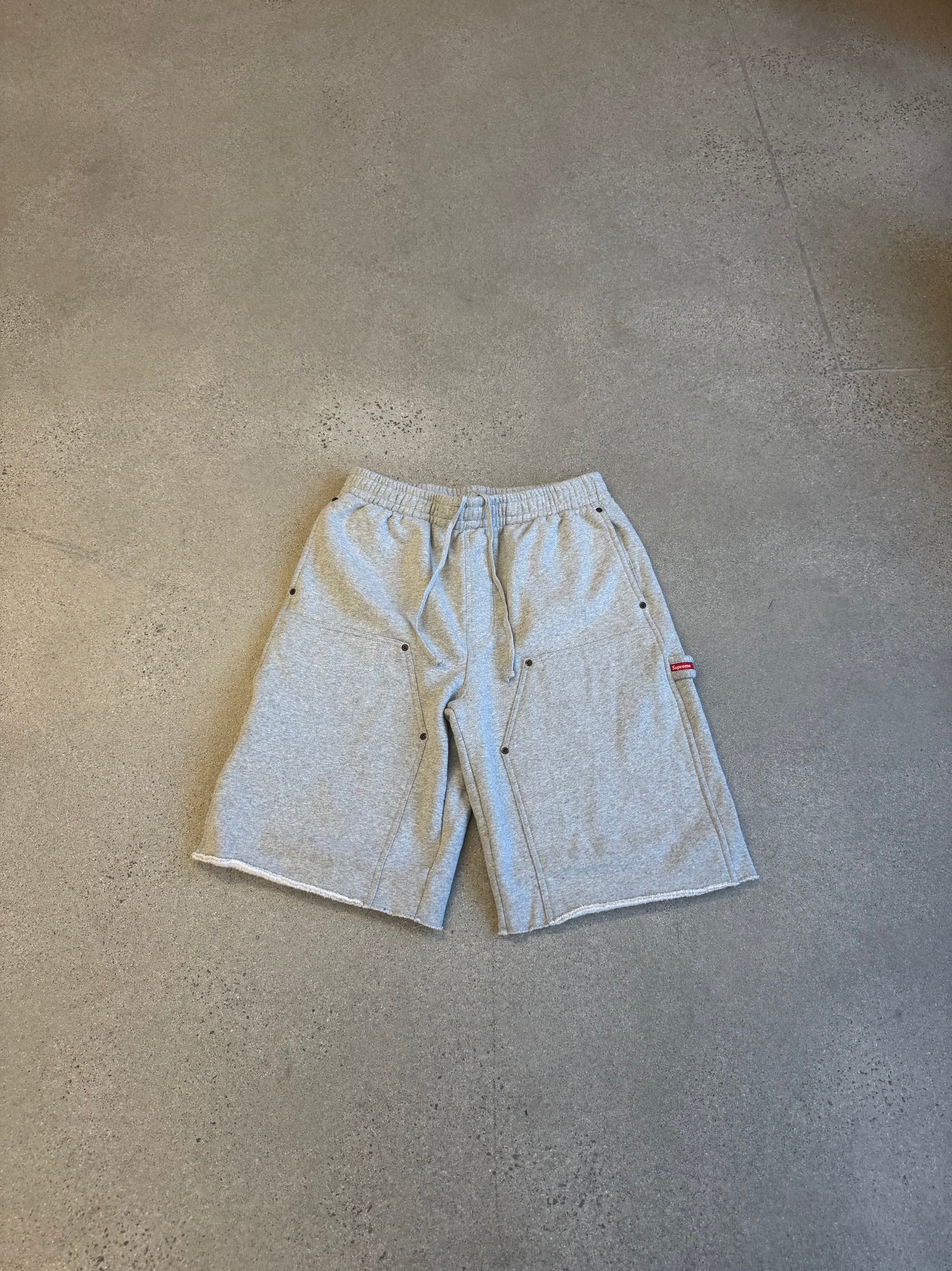 Supreme grey double knee painter sweat shorts front, utility pockets and red Supreme tab detail