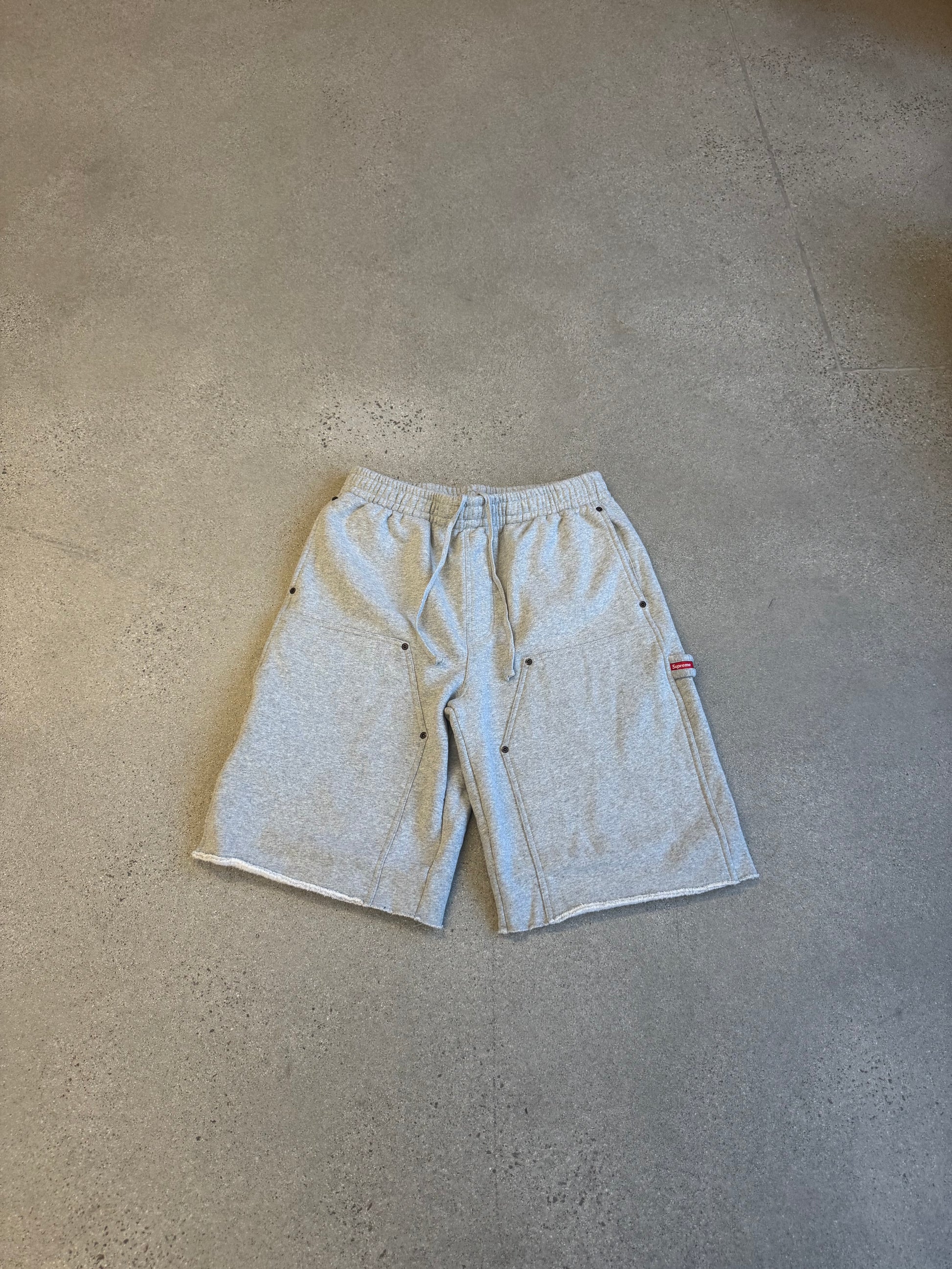 Supreme grey double knee painter sweat shorts front, utility pockets and red Supreme tab detail