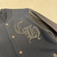 Close-up of Chrome Hearts varsity jacket CH gothic logo embroidery and silver cross button detail on navy wool