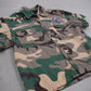 Chrome Hearts Matty Boy Sex Records camo button-up detail shot, faded green camo cotton with chest pocket.