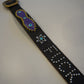 Vintage studded black belt laid flat with purple painted panel, turquoise gem star and stud-spelled text