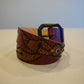 Vintage brown leather belt coiled with embossed winged-spider panel, black bead studs and matte buckle