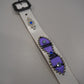 Flat view of vintage white leather belt with purple ponyhair panels, silver studs and blue gem accents