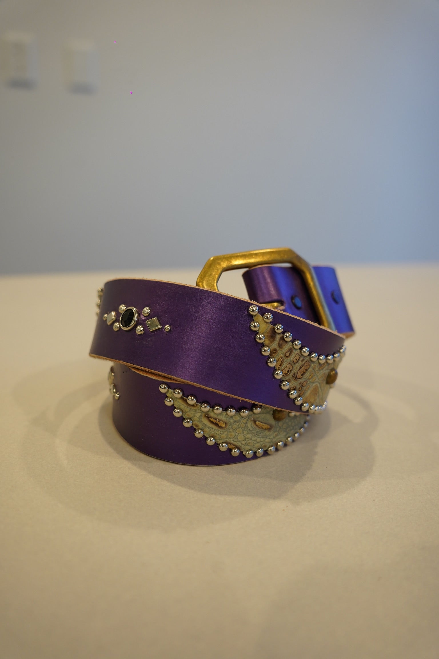 Vintage purple leather belt coiled with snakeskin wing inlays, silver bead studs and antique brass buckle