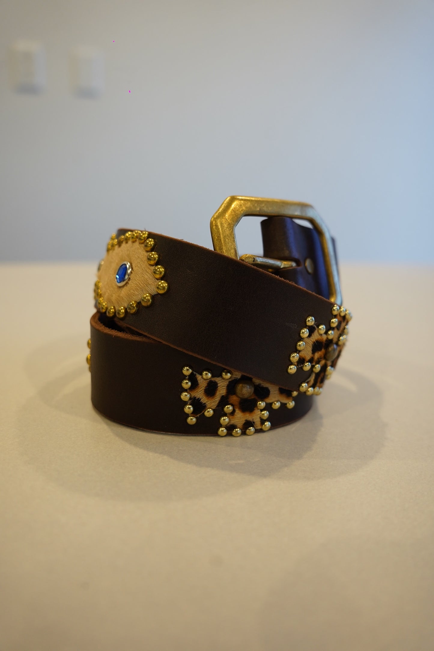 Vintage coiled brown leather belt with brass studs, blue gem accents and cheetah print hair-on calfskin patches