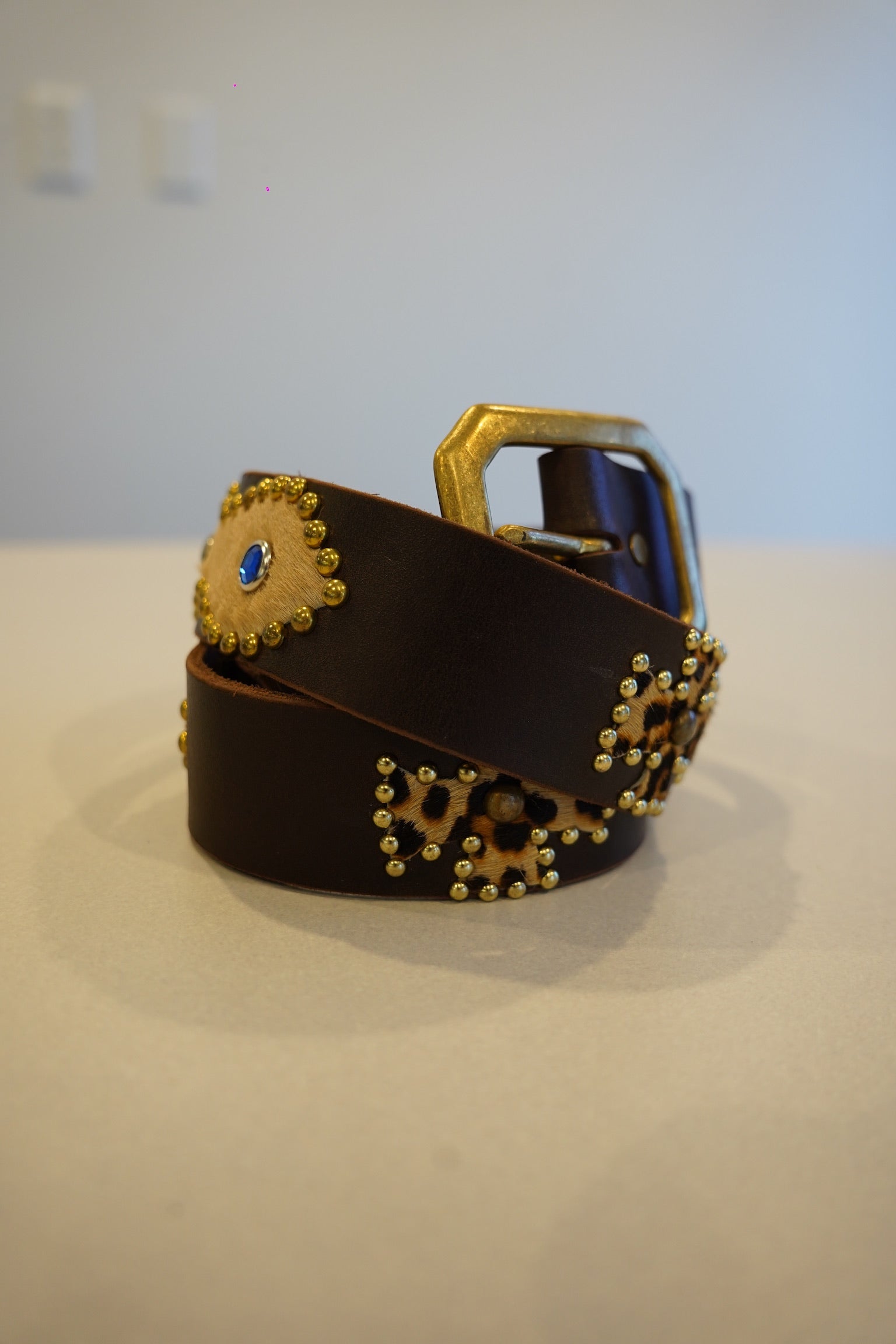 Vintage coiled brown leather belt with brass studs, blue gem accents and cheetah print hair-on calfskin patches