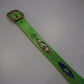Vintage green snakeskin studded leather belt laid flat with brass square buckle and gemstone accents.