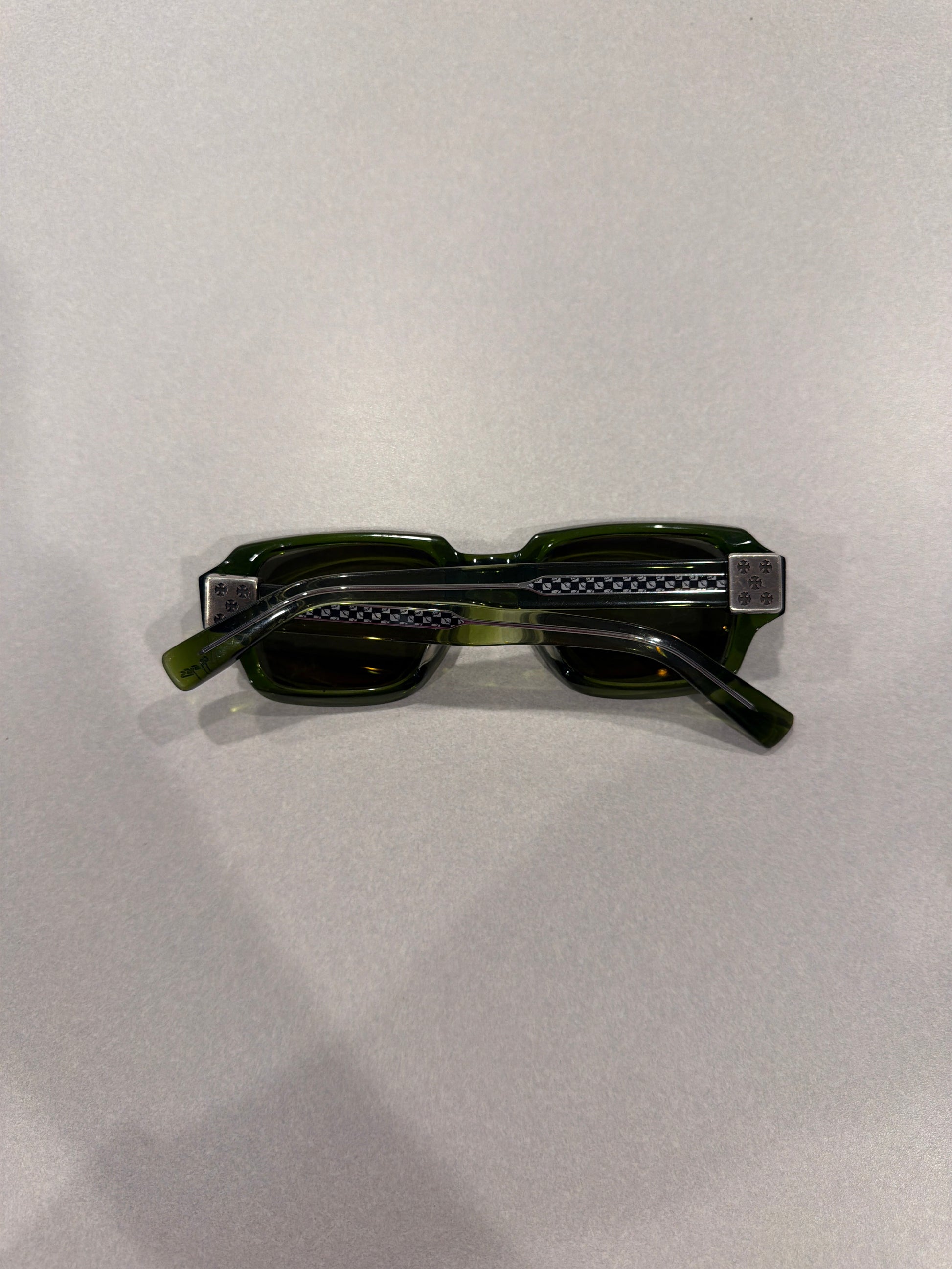 Chrome Hearts Matty Boy green sunglasses folded top-down view showing silver cross-engraved temple plates