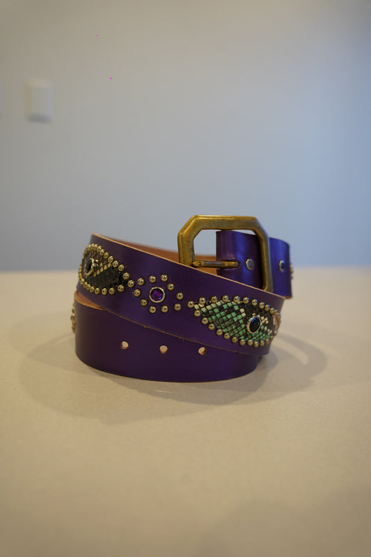 Vintage purple leather belt coiled with brass buckle, snakeskin medallion inlays and gemstone studs