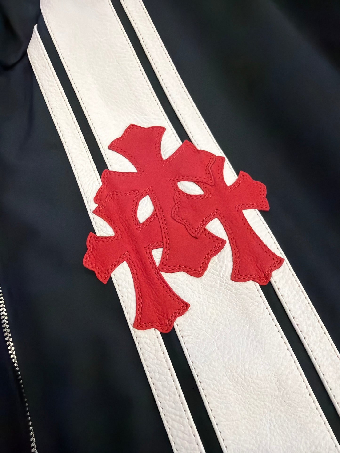 Chrome Hearts black Cobra racing jacket detail of red leather double cross patches over white leather stripes