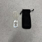 Chrome Hearts Fleur dog tag pendant shown with branded black drawstring jewelry pouch