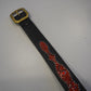Vintage studded snakeskin belt flat view with black red scale texture, metal buckle and dense stud rows