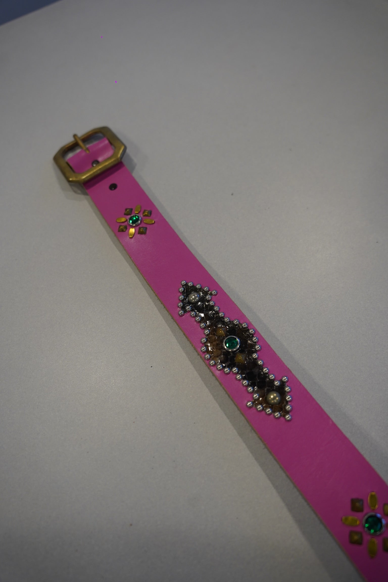 Pink snakeskin studded belt, close detail of textured scale grain and metal pyramid studs